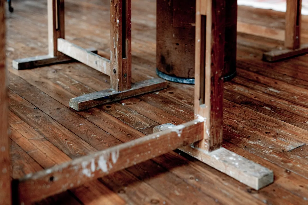 A homeowner assessing damaged hardwood flooring and a cracked wall to decide between repair or replacement.